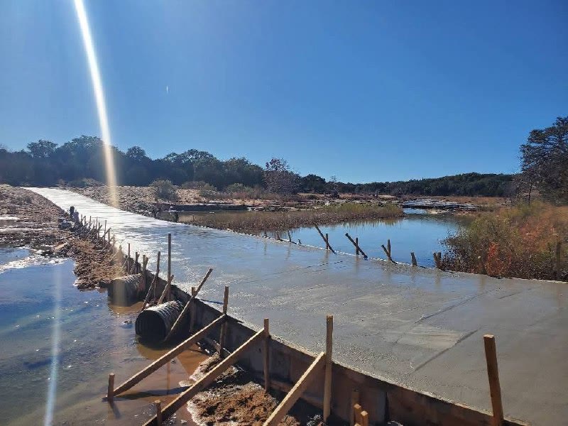 Long concrete low-water crossing under construction across a Central Texas waterway